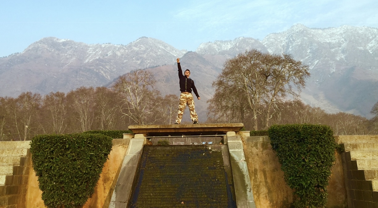 Skip on mountain plinth, arm raised
