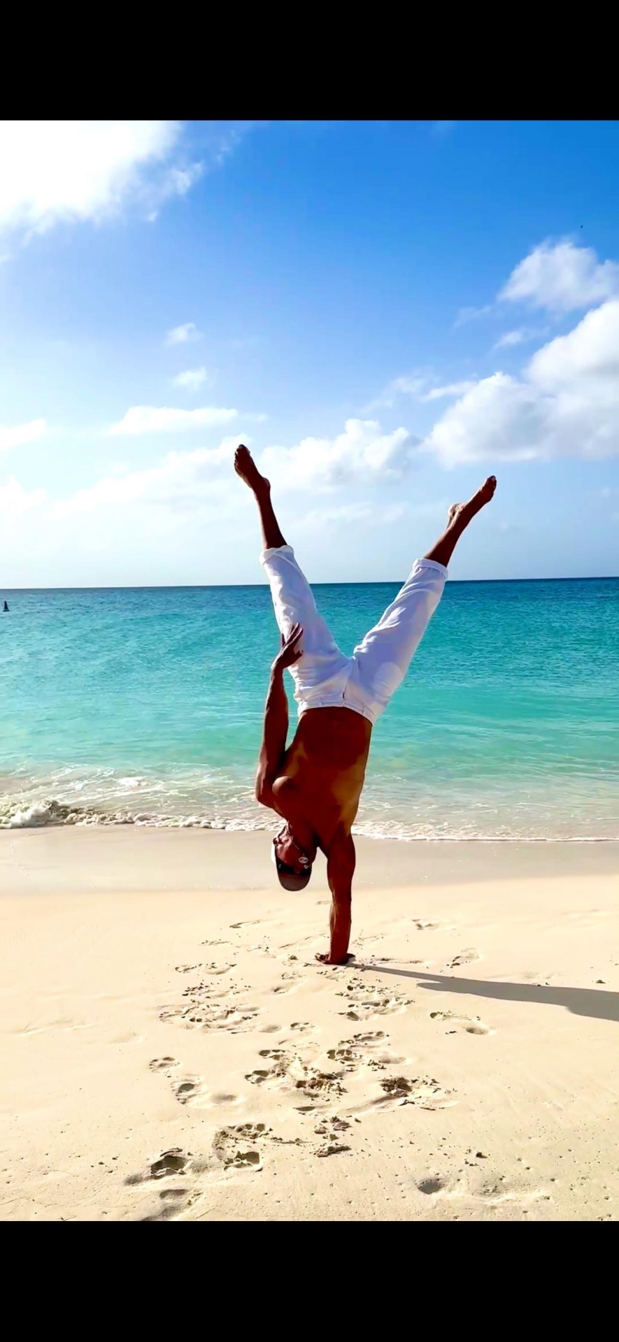 One-arm handstand on a Caribbean beach