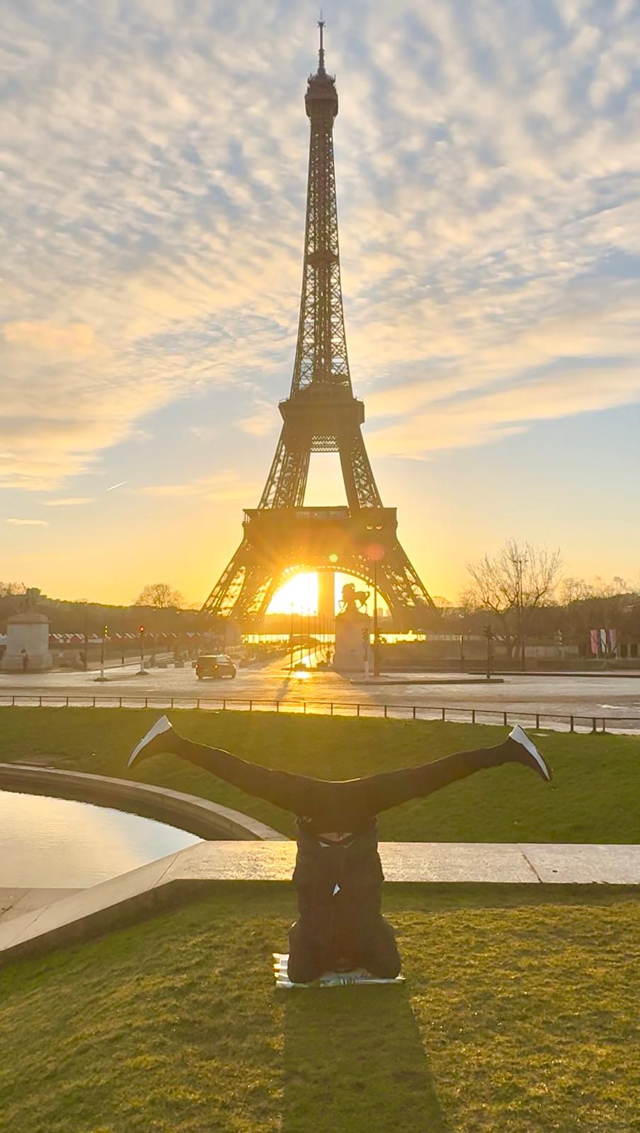Skip practicing a headstand at sunrise in front of the Eiffel Tower